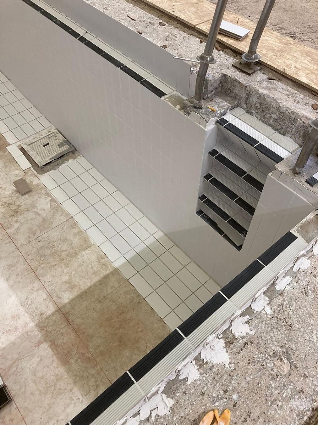 New tiles going on to the recessed step treads and risers.