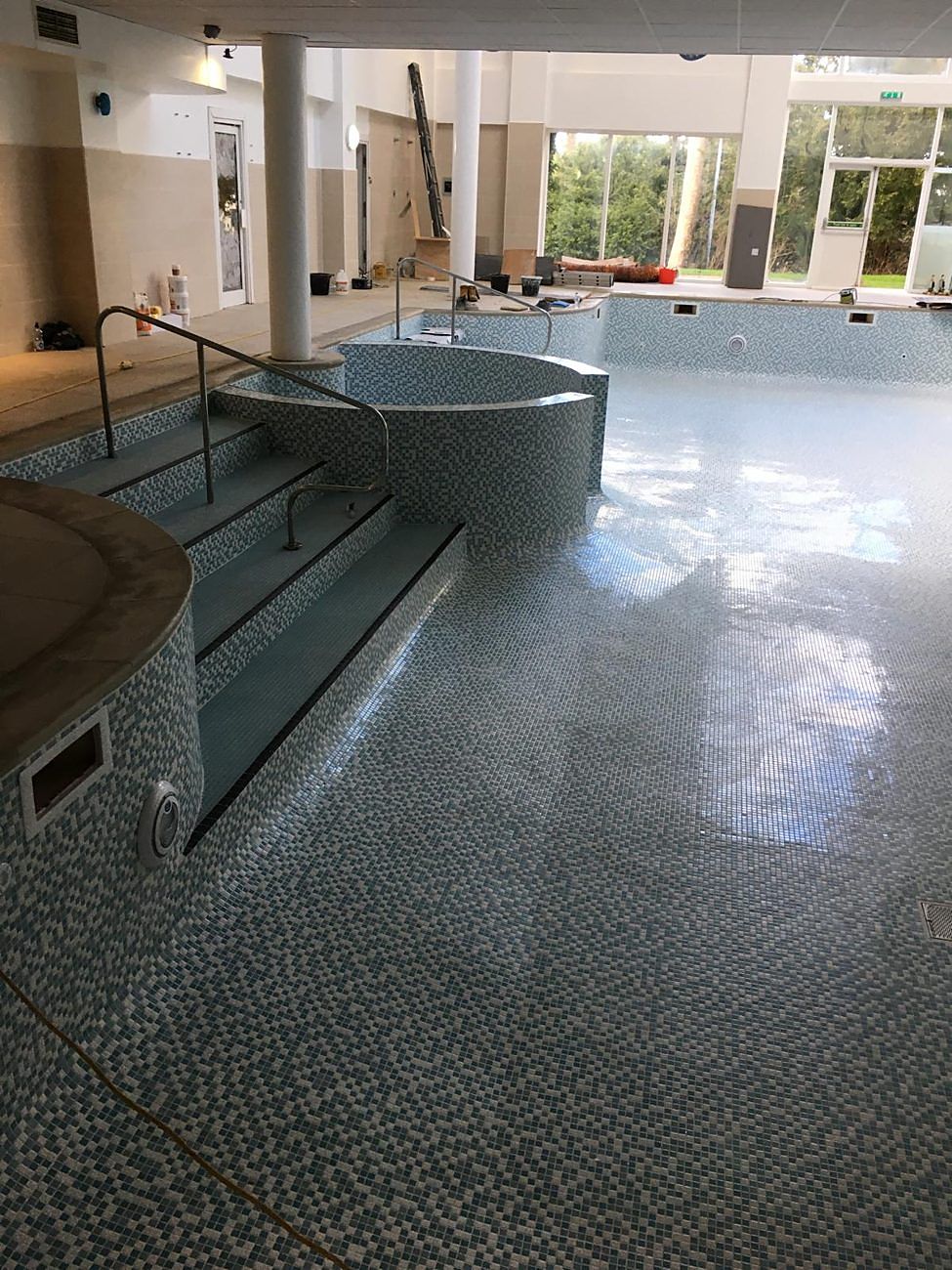 The floor tiled and grouted, with the spa seating finished.