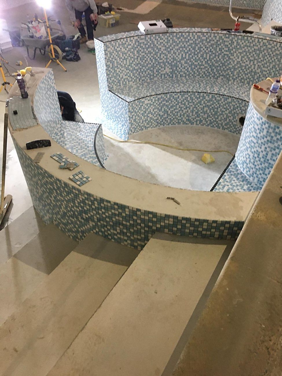 The spa seating tiled, with black edge tiles marking each seat.