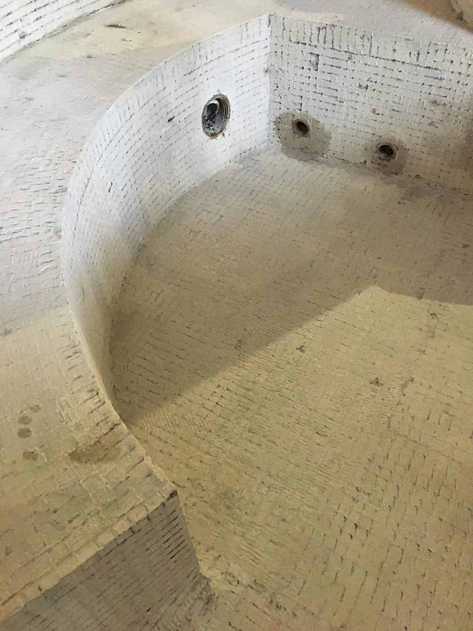 The spa stripped back to bare substrate on its walls, seat and floor.