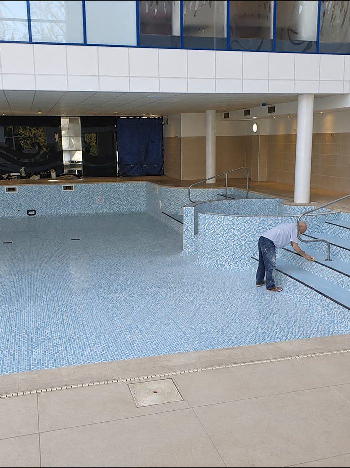 Wiping down the mosaic on the entry steps, with the pool floor finished.