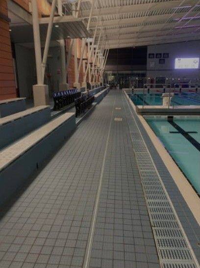Poolside tiling and drainage: Long view along a tiled pool surround and channel.